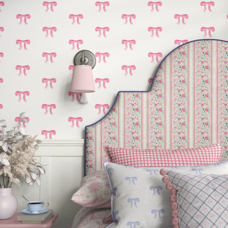 Matilda Bow wallpaper by Willow and Woods, in pink, decorates bedroom wall.