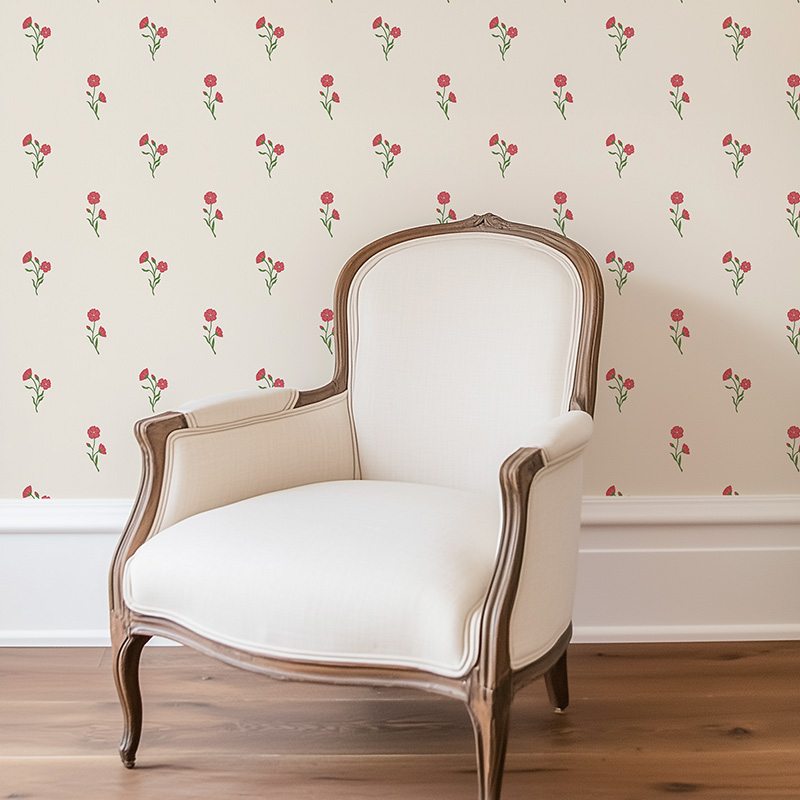 Found Flower Rose Red floral wallpaper with small scale hand drawn flower pattern in muted red with pink accents and green stems, decorates wall behind armchair.